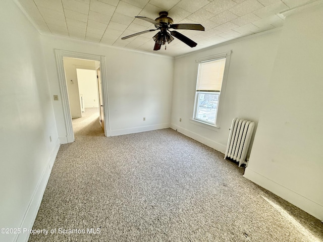 spare room featuring ornamental molding, radiator, light carpet, and baseboards