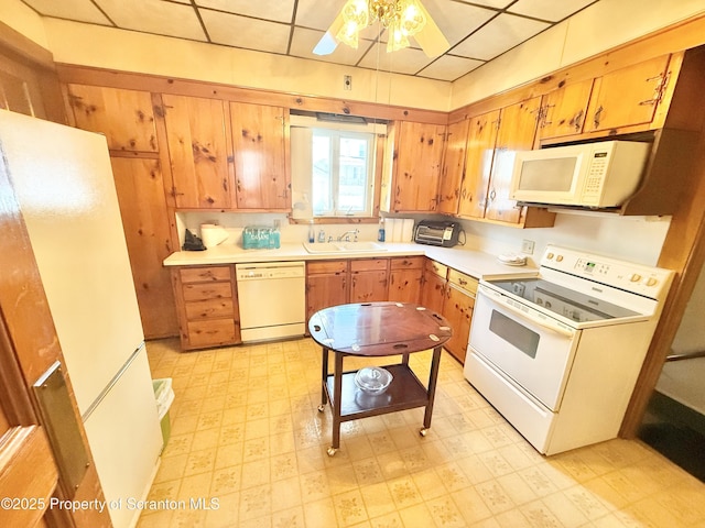 kitchen featuring white appliances, a sink, a ceiling fan, light countertops, and light floors