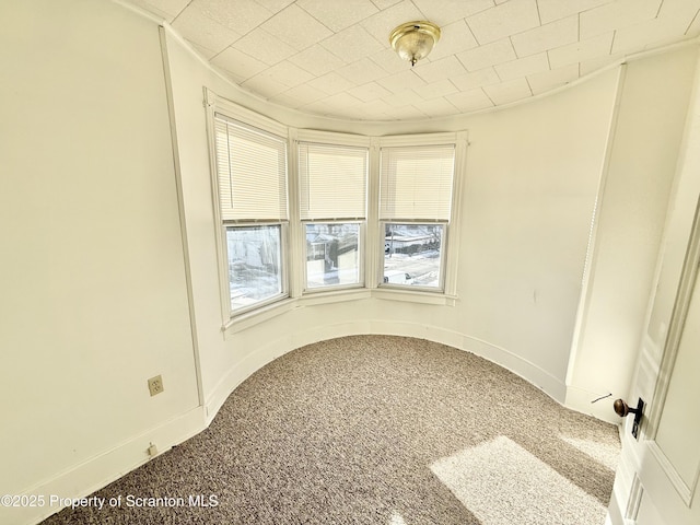 spare room with carpet and baseboards