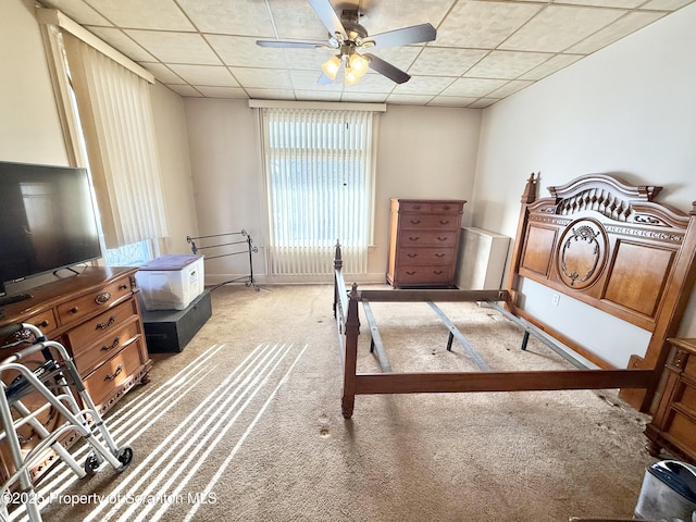 bedroom with baseboards, ceiling fan, a paneled ceiling, and light colored carpet