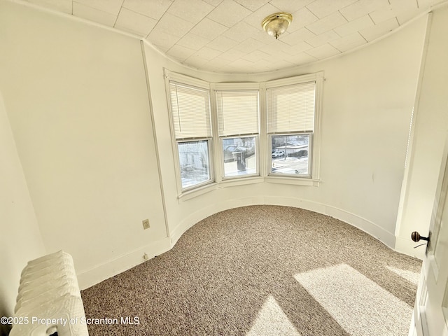 carpeted spare room with baseboards