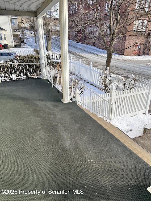 snow covered patio with a porch