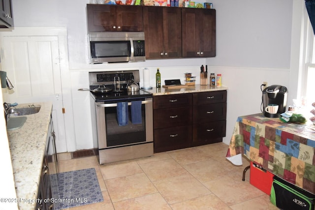 616 Delaware St, Scranton, PA 18509 - kitchen with stainless steel appliances, dark brown cabinets, and light stone counters