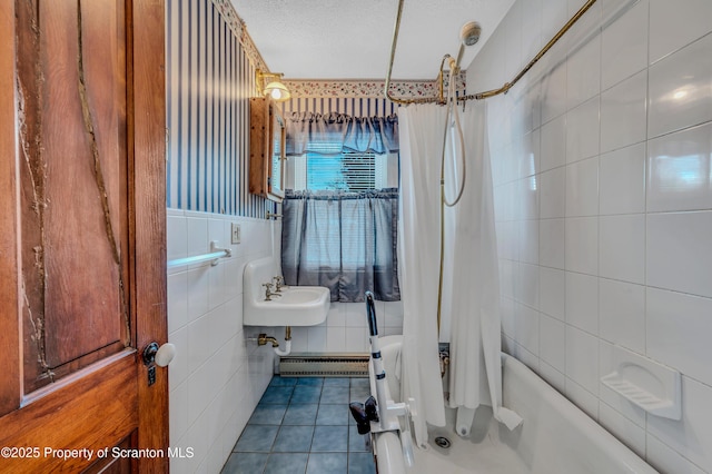 bathroom with tile patterned floors, sink, a textured ceiling, tile walls, and shower / bath combo