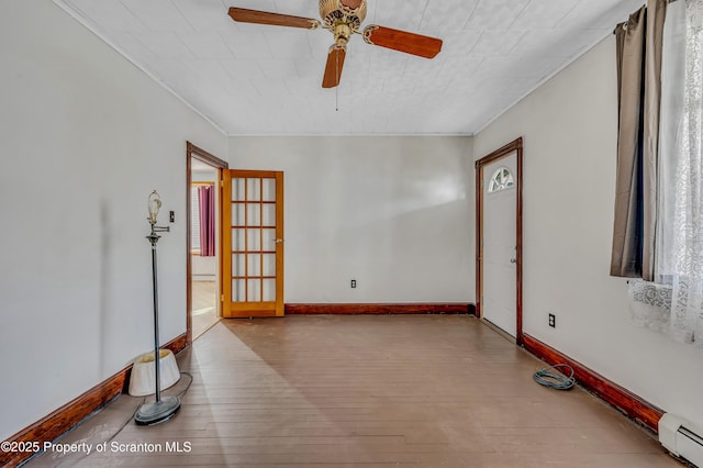 unfurnished room with ceiling fan, light wood-type flooring, and baseboard heating