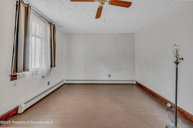 unfurnished room featuring a baseboard heating unit, ceiling fan, and light hardwood / wood-style flooring