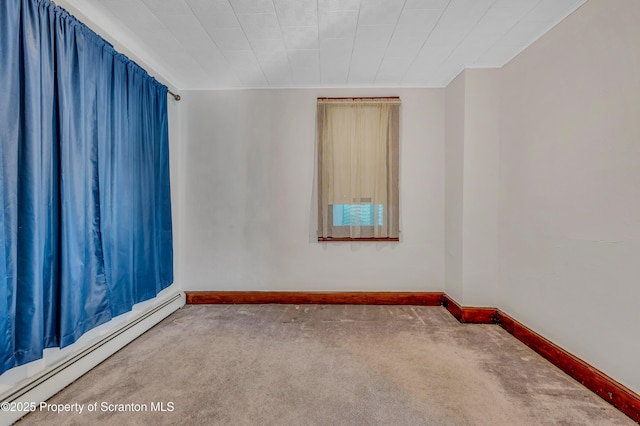 carpeted empty room with a baseboard heating unit