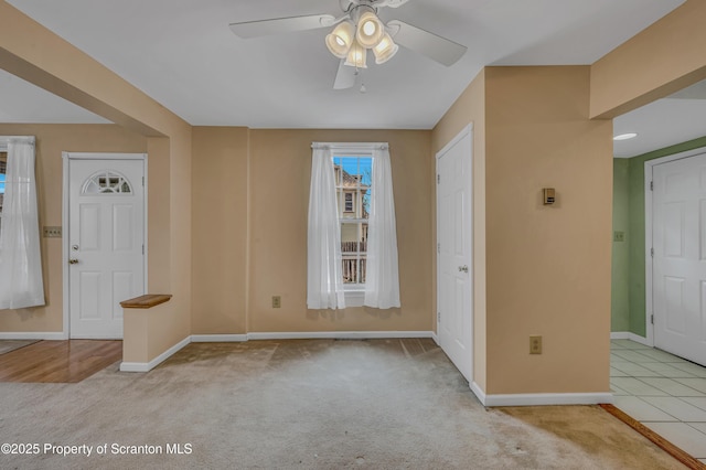 spare room with ceiling fan, baseboards, and carpet