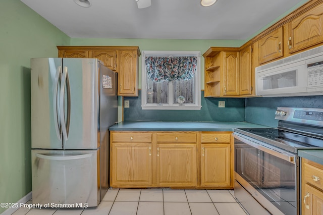 kitchen featuring light tile patterned floors, appliances with stainless steel finishes, brown cabinetry, and light countertops