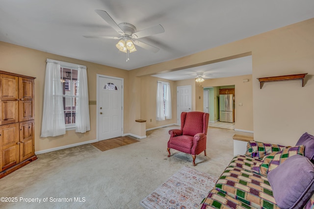 living room featuring a ceiling fan, baseboards, and carpet floors