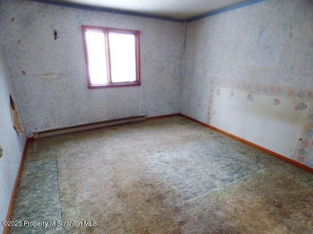 carpeted empty room featuring baseboard heating