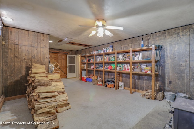 below grade area with ceiling fan and wooden walls