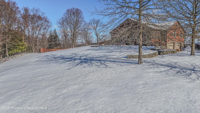 yard covered in snow featuring a barn