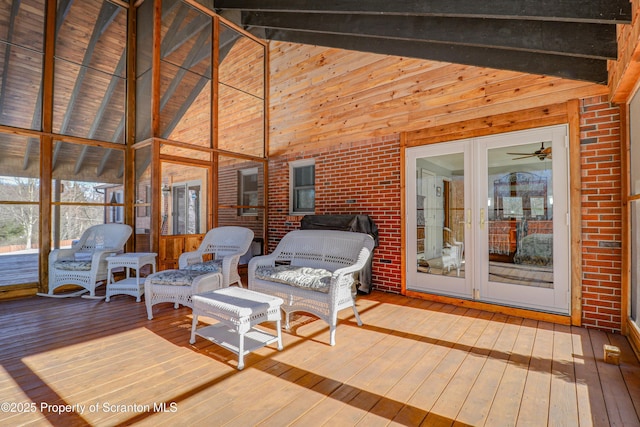 sunroom / solarium with lofted ceiling with beams and a ceiling fan