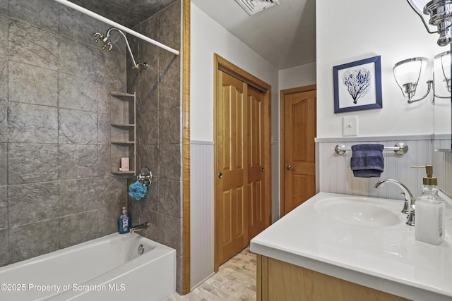 bathroom with a wainscoted wall, shower / bathtub combination, vanity, and visible vents