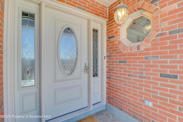 doorway to property with brick siding