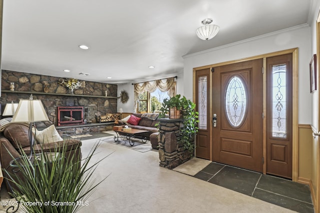 foyer with ornamental molding, a fireplace, and recessed lighting