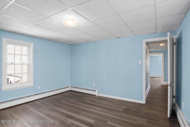 316 Sibley Ave, Old Forge, PA 18518 - empty room with a baseboard radiator, dark wood-style flooring, baseboard heating, baseboards, and a paneled ceiling