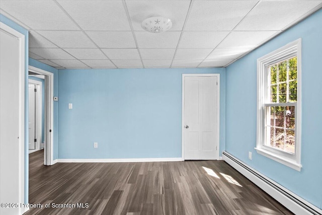 316 Sibley Ave, Old Forge, PA 18518 - empty room with a baseboard heating unit, wood finished floors, baseboards, and a paneled ceiling