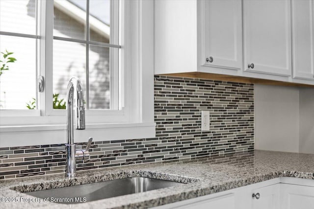 316 Sibley Ave, Old Forge, PA 18518 - kitchen with a sink, white cabinets, backsplash, and light stone countertops