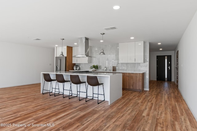 203 Red Oak Dr, Olyphant, PA 18447 - kitchen with a breakfast bar, high end fridge, visible vents, wall chimney exhaust hood, and modern cabinets