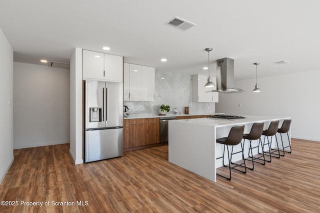 203 Red Oak Dr, Olyphant, PA 18447 - kitchen with visible vents, wall chimney exhaust hood, wood finished floors, and appliances with stainless steel finishes