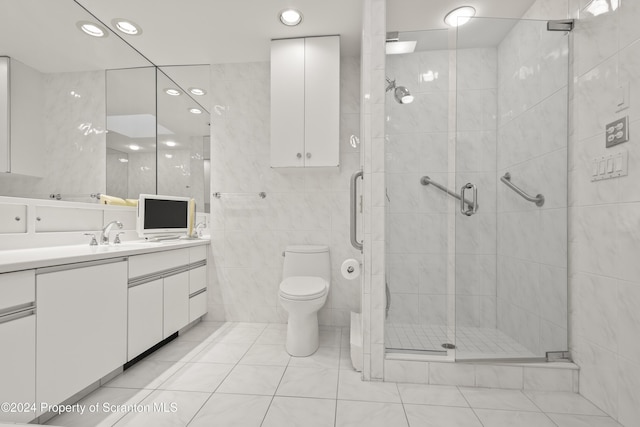 bathroom featuring tile walls, a shower with shower door, toilet, tile patterned floors, and vanity