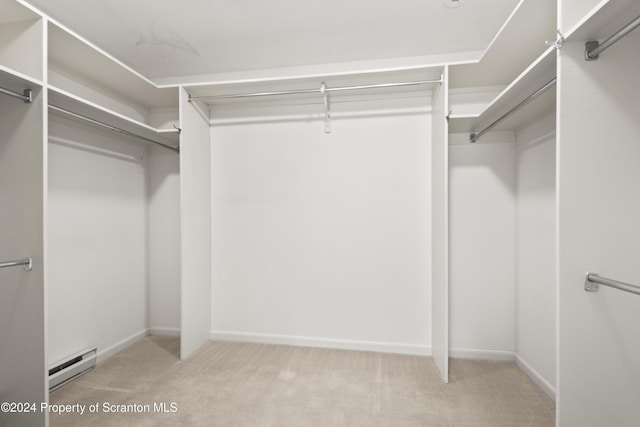 walk in closet featuring a baseboard radiator and light colored carpet