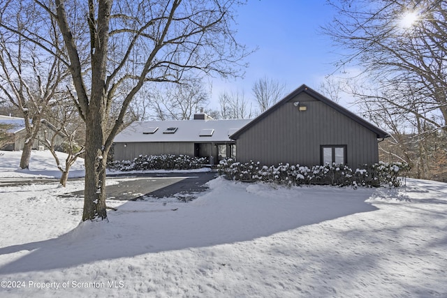 view of snow covered rear of property