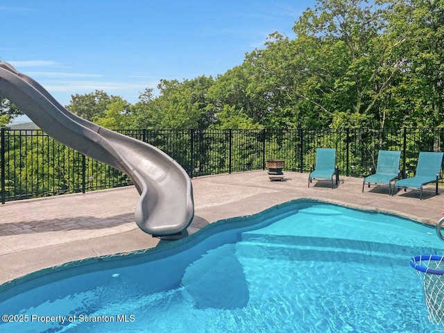 view of pool with a patio, a water slide, fence, and a fenced in pool