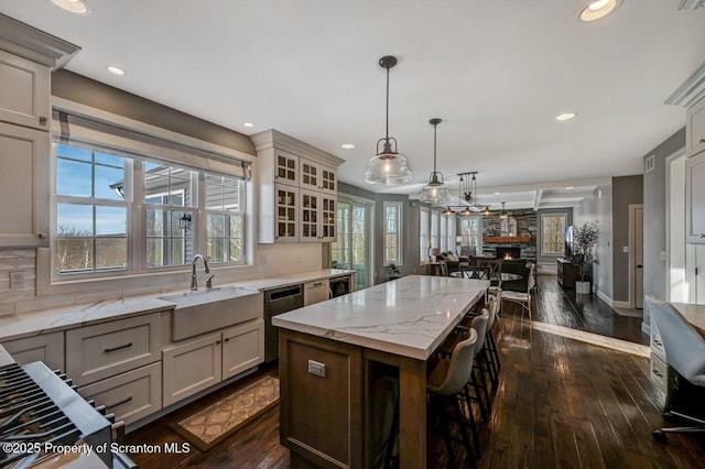 kitchen featuring a kitchen island, decorative backsplash, open floor plan, and a sink