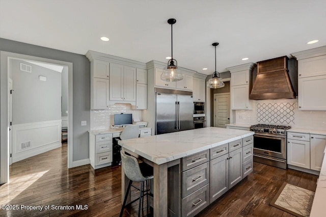 kitchen with gray cabinetry, a kitchen island, high quality appliances, dark wood-style floors, and custom range hood