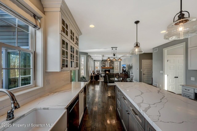 kitchen with tasteful backsplash, dark wood finished floors, dishwasher, pendant lighting, and a sink