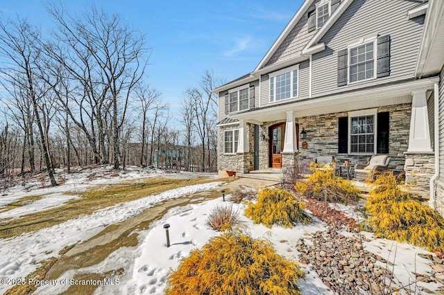 exterior space with stone siding and a porch