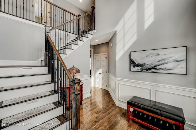 stairway featuring wainscoting and wood finished floors