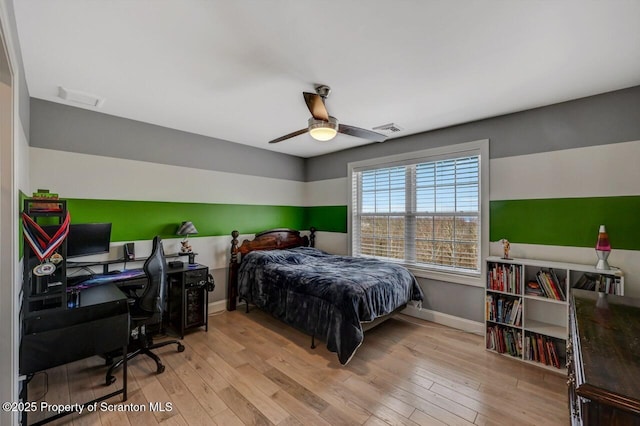 bedroom featuring ceiling fan, wood-type flooring, visible vents, and baseboards