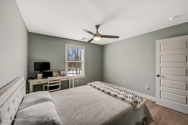 bedroom with a ceiling fan, baseboards, visible vents, and wood finished floors