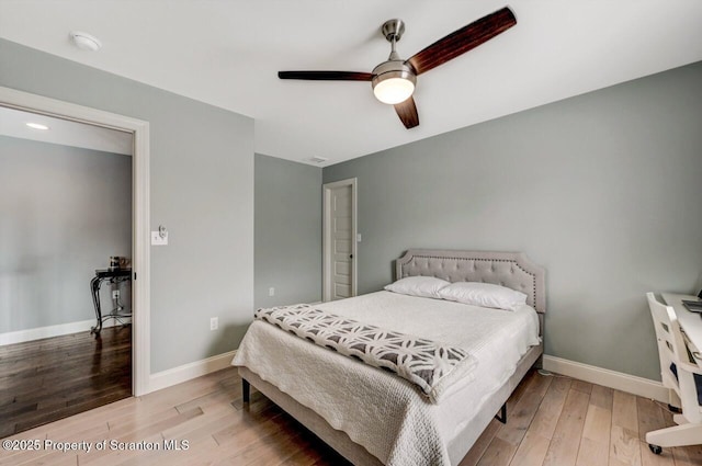 bedroom with wood finished floors, a ceiling fan, and baseboards