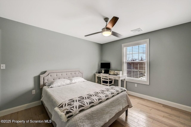 bedroom featuring light wood-style floors, visible vents, and baseboards