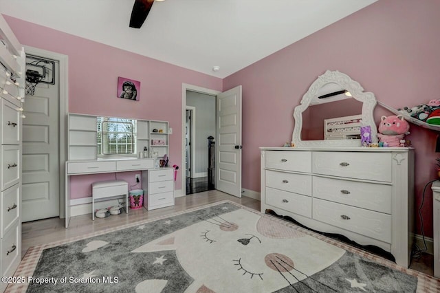 bedroom featuring a ceiling fan, baseboards, and light wood finished floors