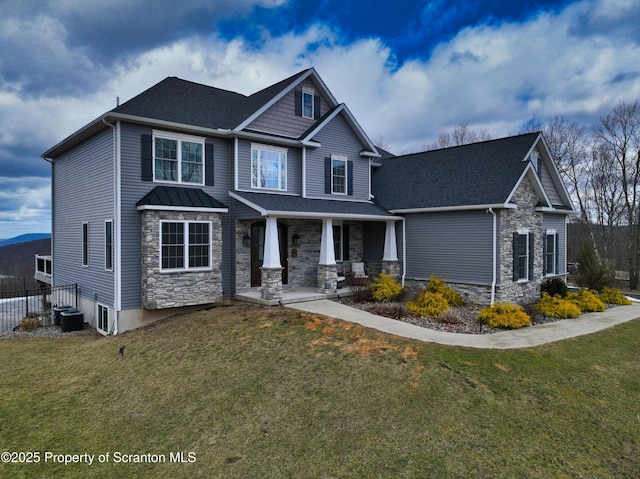 craftsman house featuring covered porch, stone siding, a front lawn, and central AC unit