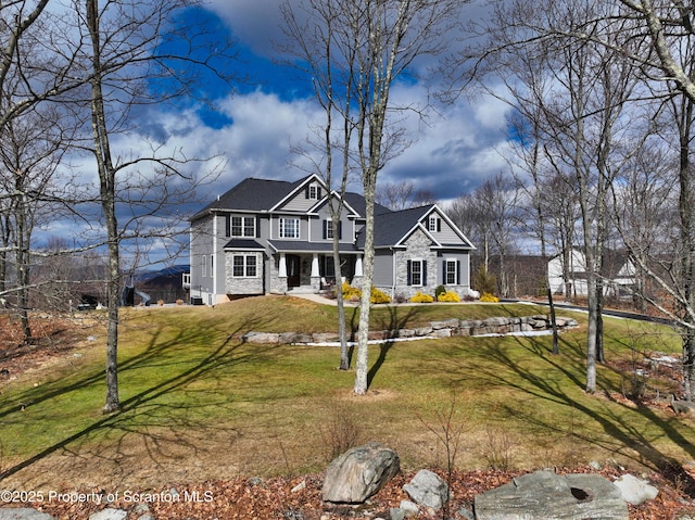 traditional home featuring stone siding and a front yard