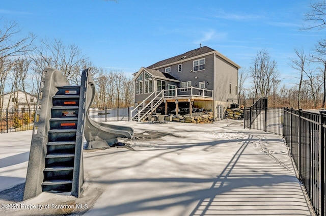 back of property with stairway, a gate, fence, and a wooden deck