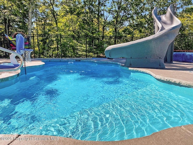 view of pool featuring a fenced in pool, a water slide, and fence