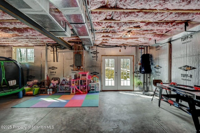 recreation room with electric panel, concrete flooring, and french doors