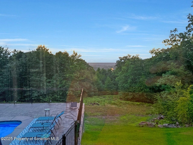 view of yard featuring a patio and a wooded view