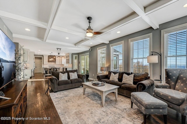 living room featuring coffered ceiling, beamed ceiling, and wood finished floors