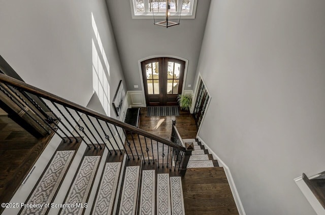 foyer entrance featuring arched walkways, french doors, wood finished floors, and stairs