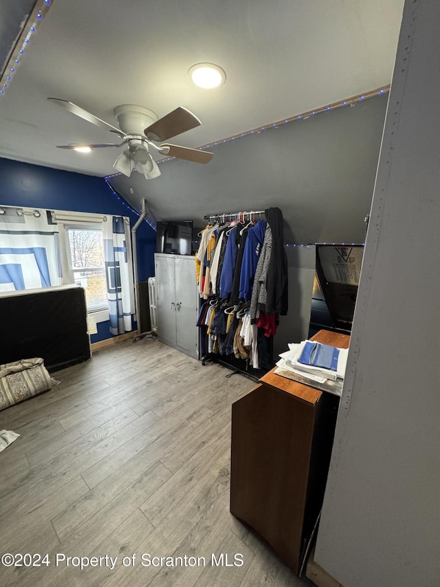 spacious closet featuring ceiling fan, light hardwood / wood-style flooring, and vaulted ceiling