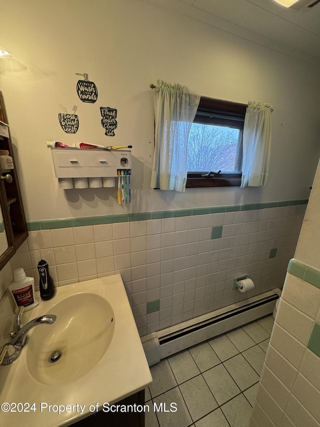 bathroom with tile patterned flooring, vanity, baseboard heating, and tile walls